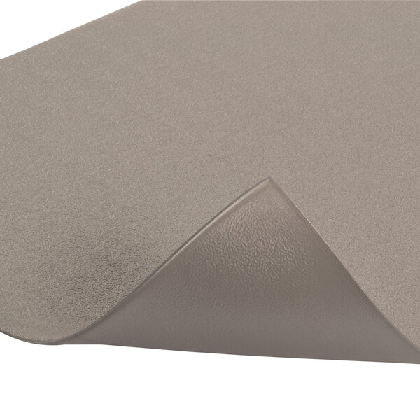 A close-up of a grey Notrax Cushion Stat Anti-Fatigue Mat with a folded edge.