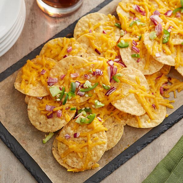 A plate of nachos with Daiya vegan shredded cheddar cheese and onions.