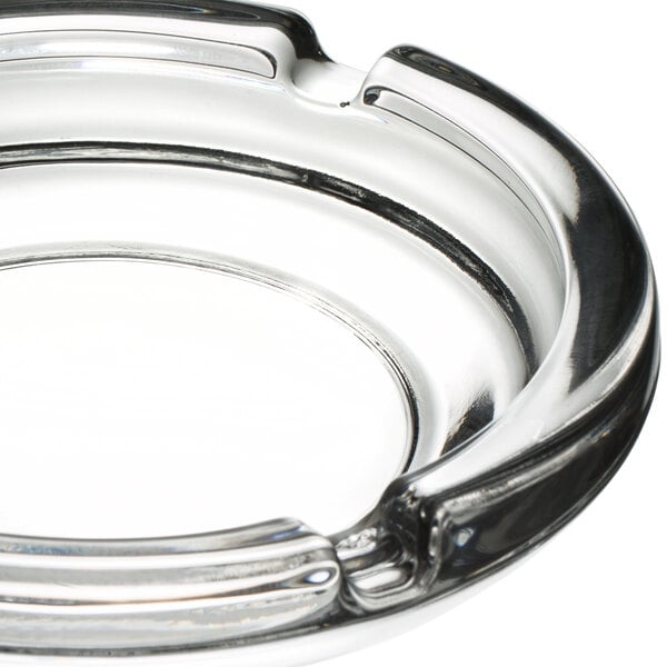 A close up of a Libbey glass round ashtray with a circular rim.