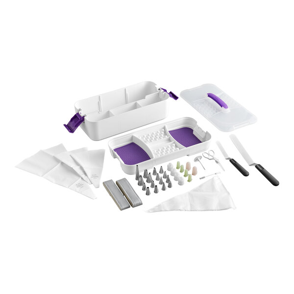 A cake decorating set with various metal tips, spatulas, piping bags, couplers, scissors, and a white plastic storage case with purple accents.