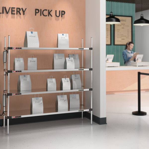 A Metro heated takeout station with white bags on the shelves.