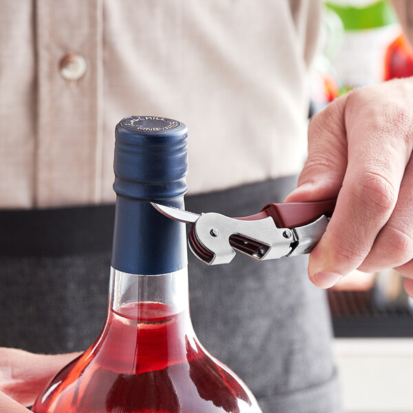 A person using an Acopa Waiter's Corkscrew to open a bottle of wine.