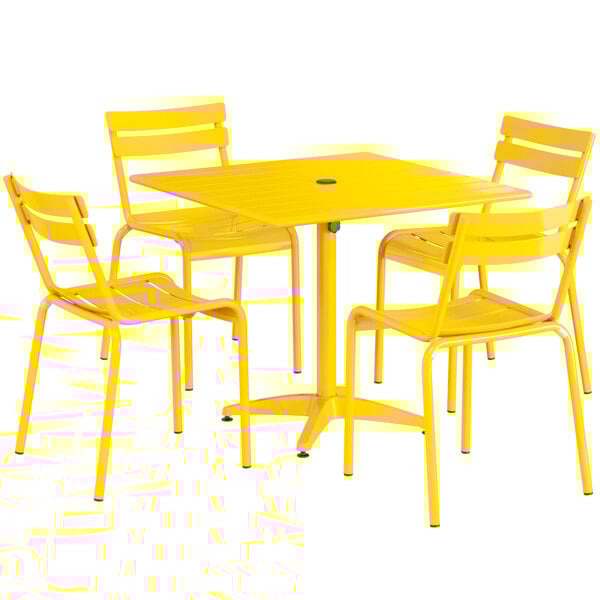 A yellow table and chairs on an outdoor patio.