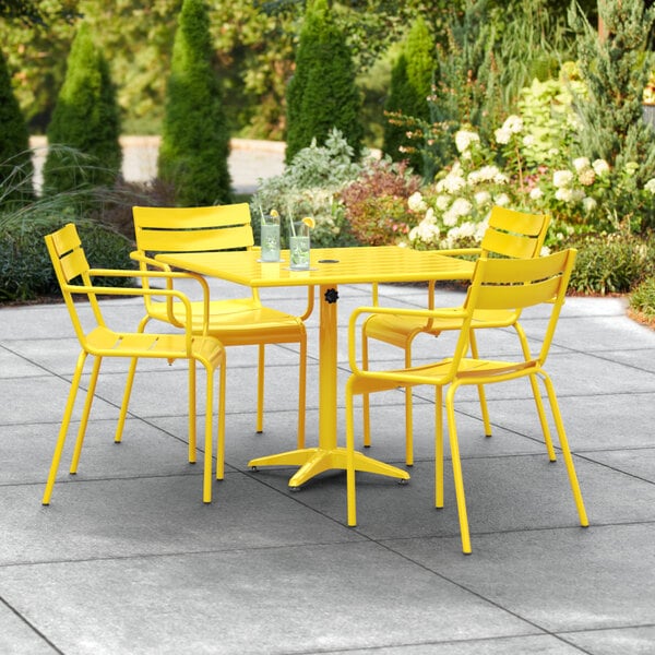 A yellow table and chairs on a patio.