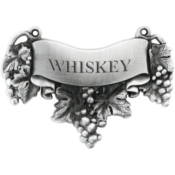 A silver metal sign with the word "Whiskey" and grapes and leaves on it.