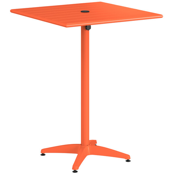 A Lancaster Table & Seating orange powder-coated aluminum bar height table with a metal pole.