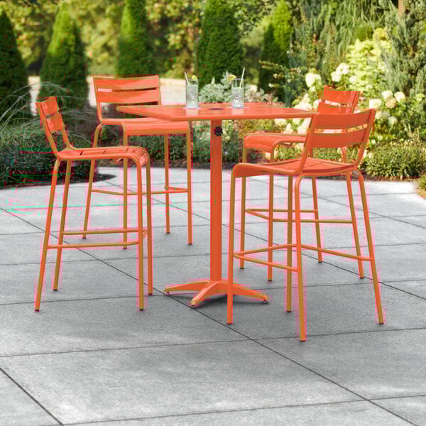 An orange table with chairs on a patio.