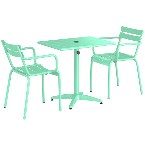 A Lancaster Table & Seating seafoam green table with umbrella hole and two arm chairs.