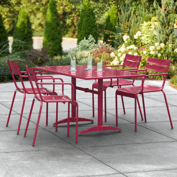 A red outdoor table with chairs on a patio.