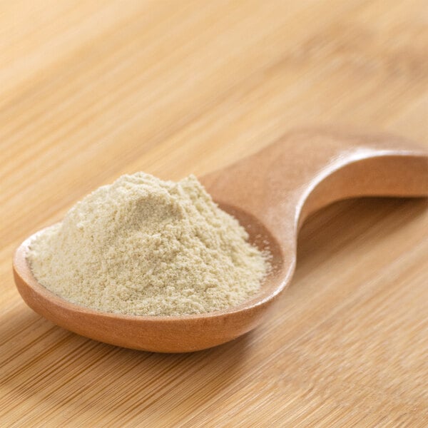 A wooden spoon scooping citrus fiber powder.