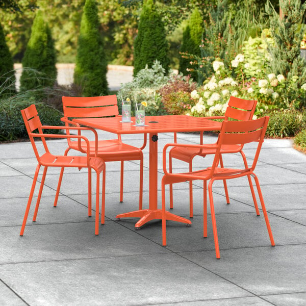 An orange table and chairs on a patio.