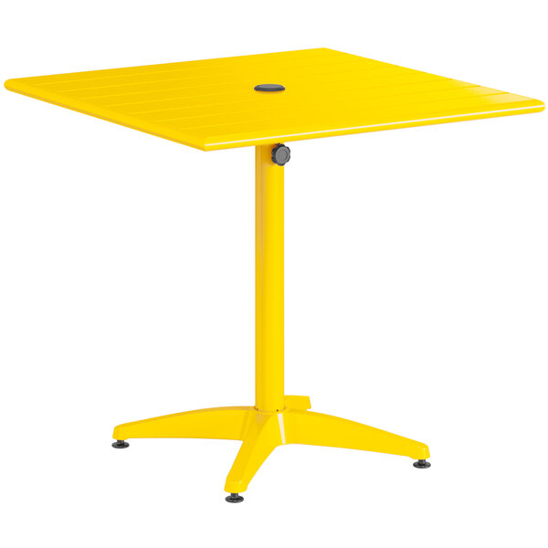 A yellow square Lancaster Table & Seating outdoor table with a metal base.