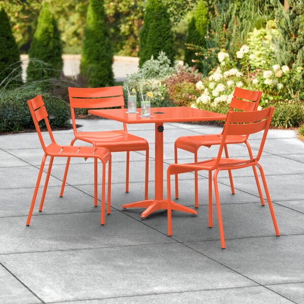 An orange table and chairs on a patio.