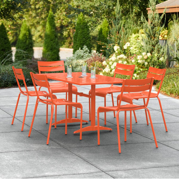 An orange table and chairs on a patio.