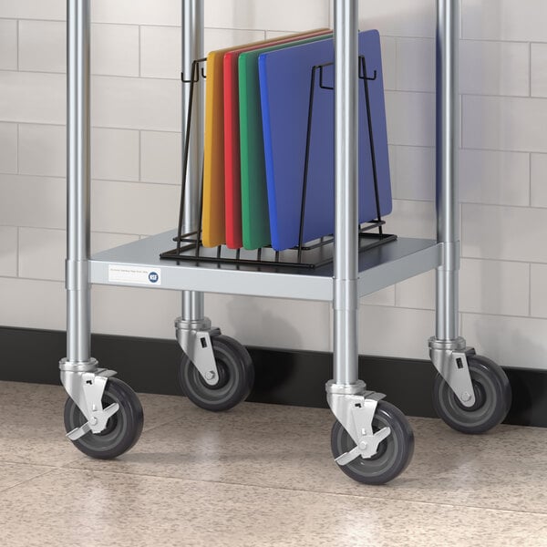 A metal cart with Regency heavy duty swivel stem casters holding cutting boards.