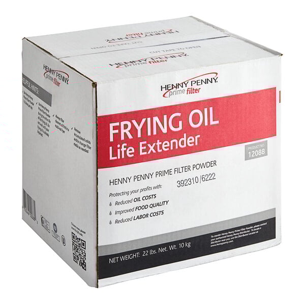A white box with red and black text for Henny Penny Frying Oil Extender on a professional kitchen counter.