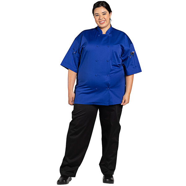 A woman wearing a Uncommon Chef deep royal blue short sleeve chef coat.