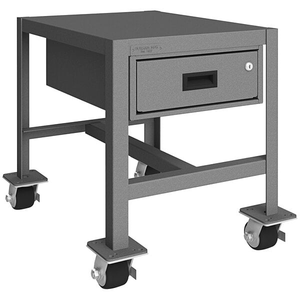 A gray metal Durham machine table with wheels and a drawer.