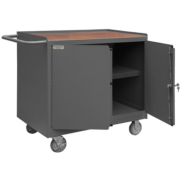 A Durham gray and brown mobile workstation with a hardboard top and open door.