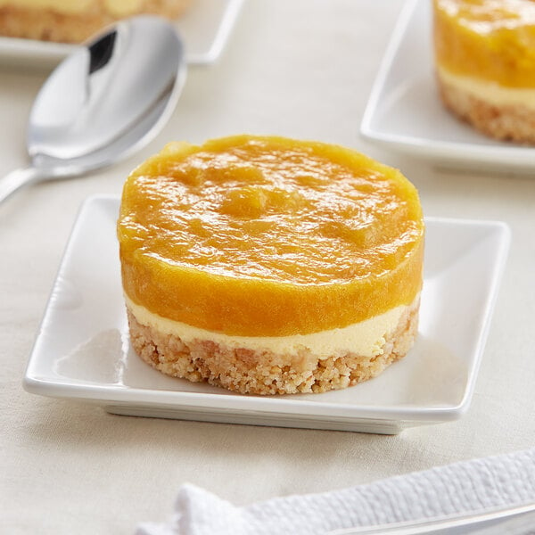 A white square plate with a slice of White Toque mango passion cake on it.