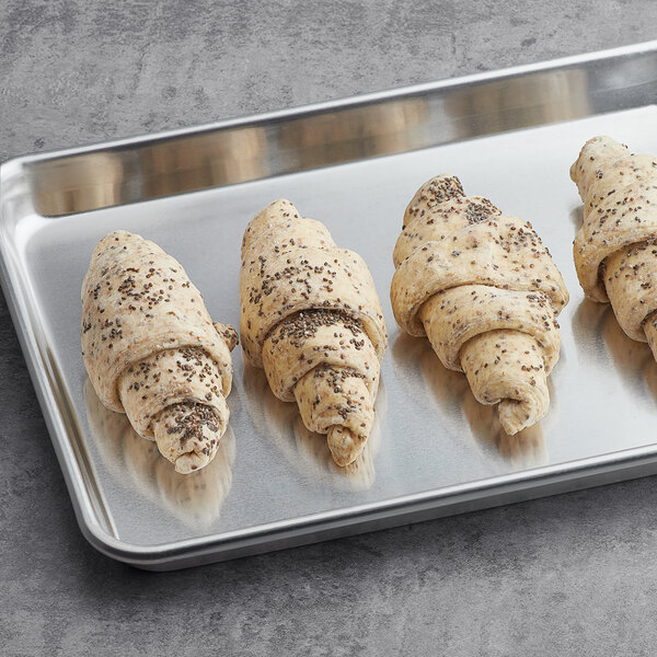 A baking sheet with four Lizzi Vegan Chia Seed croissants on it.