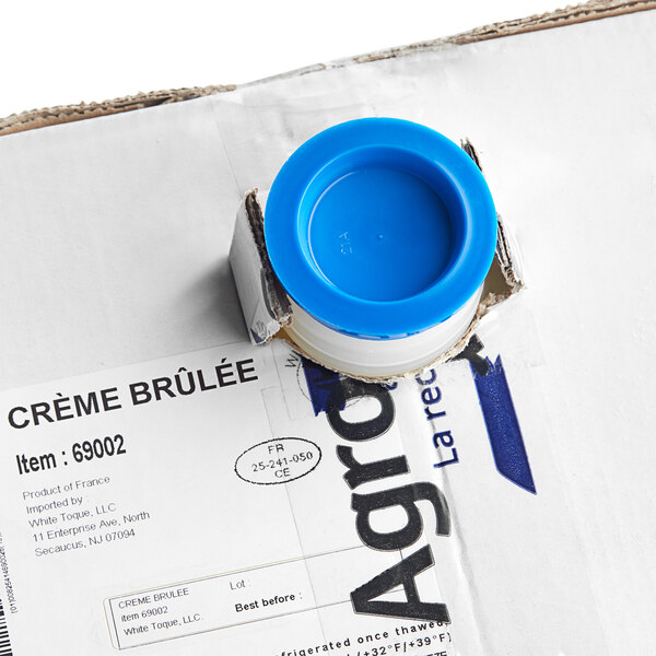 A white box with a blue lid and a blue Toque ring containing Creme Brulee mix.