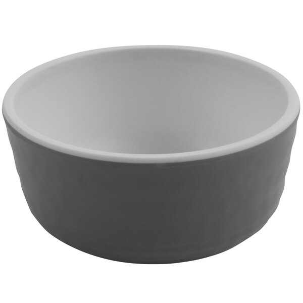 A gray sauce dish with a white rim.