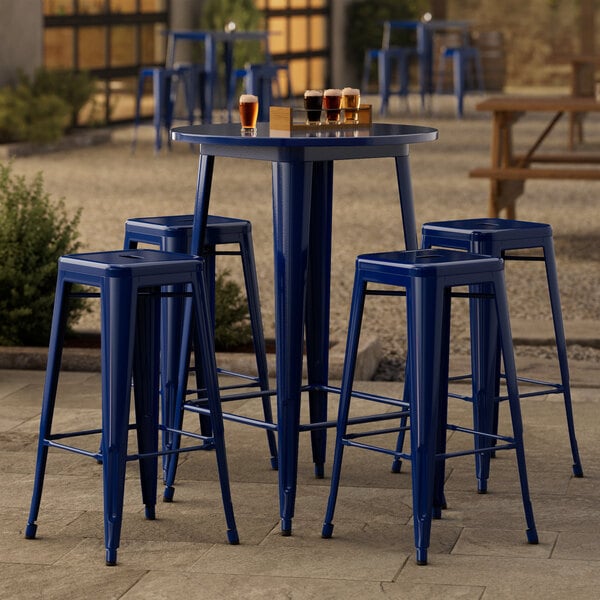 A Lancaster Table & Seating blue metal bar height table with 4 backless barstools.