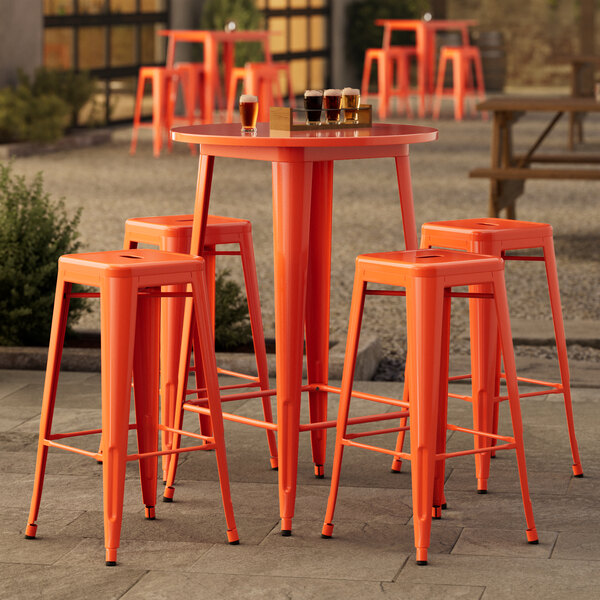 Lancaster Table & Seating bar height outdoor table with orange barstools.