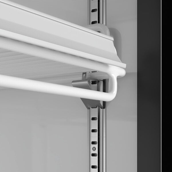 A white shelf with metal rods inside a MainStreet Equipment black swing glass door merchandiser.