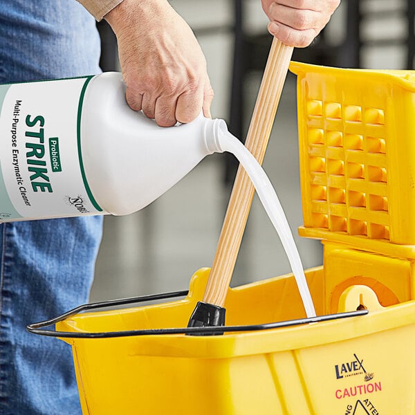 A person pouring Noble Eco Strike cleaner into a bucket.