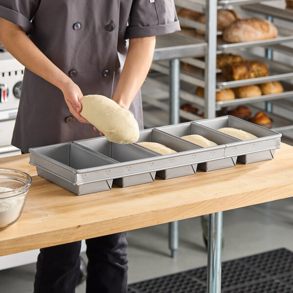 A five-strap glazed aluminized steel bread loaf pan designed for baking multiple loaves at once.