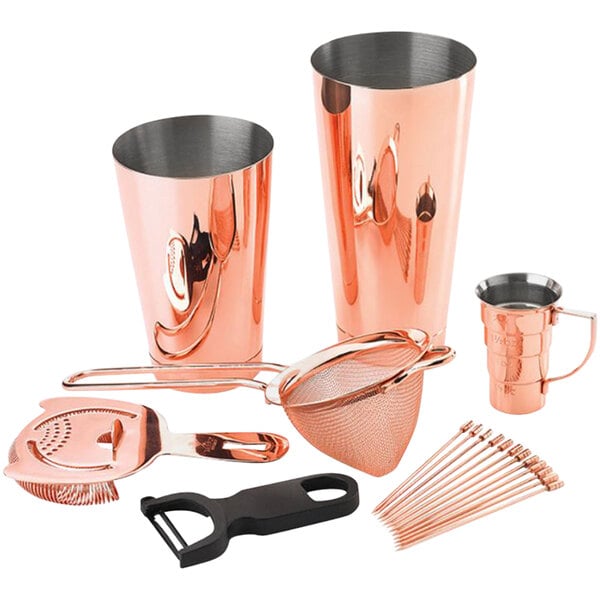 A Barfly copper cocktail tool kit on a counter with copper shakers and utensils.