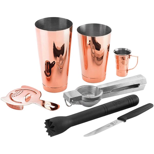 A set of copper cocktail tools on a counter.