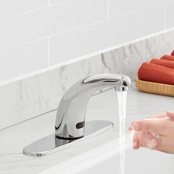 A person washing their hands under a Waterloo hands-free sensor faucet on a counter.