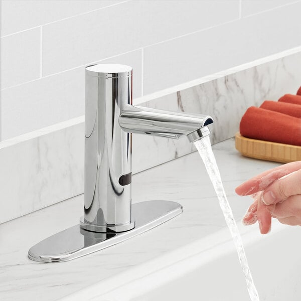 A person washing their hands under a Waterloo hands-free faucet.