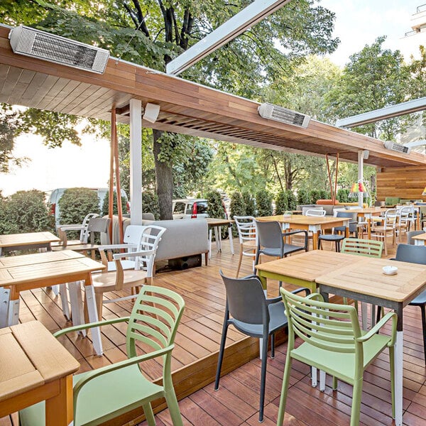 An Aura carbon infrared heater on a table on a wooden deck with chairs.