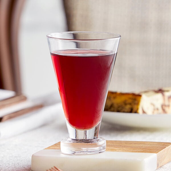 A close-up of a Fortessa Temptationz port glass filled with red liquid.