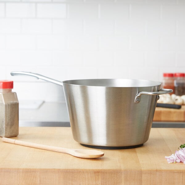 Vollrath tapered sauce pan sitting on a wooden counter