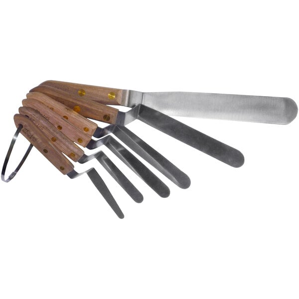 A group of metal tools with wooden handles including offset spatulas.