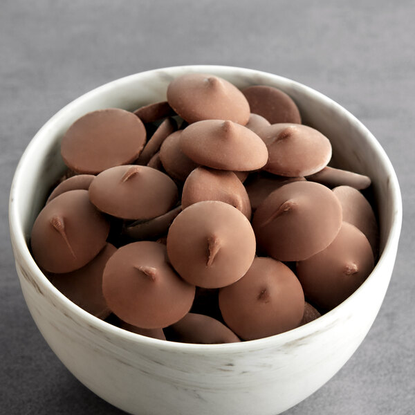 A bowl of Ghirardelli milk chocolate wafers.