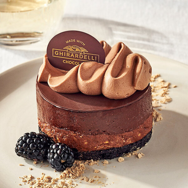 A chocolate cake with Ghirardelli 52% Non-Dairy Chocolate Chips and berries on top.