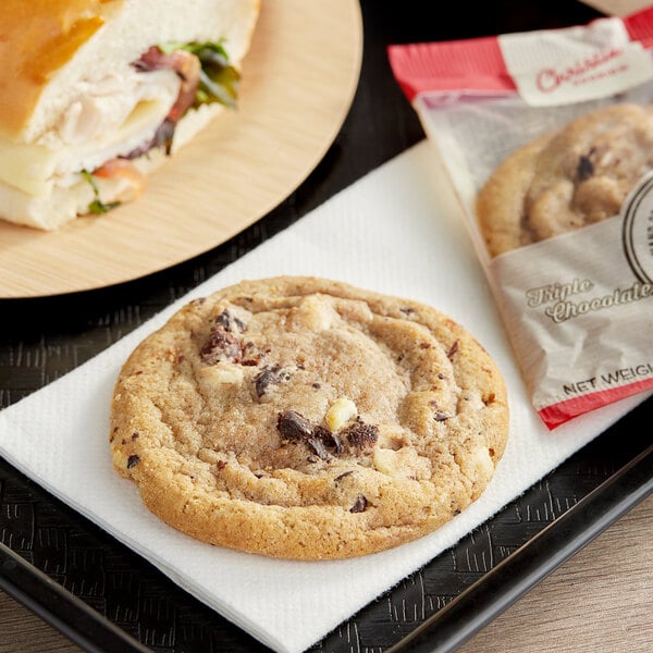 A Christie Cookie Co. triple chocolate blonde cookie and a sandwich on a tray.