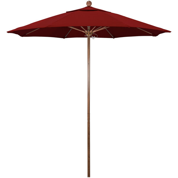 A close-up of a red California Umbrella with a wooden pole.