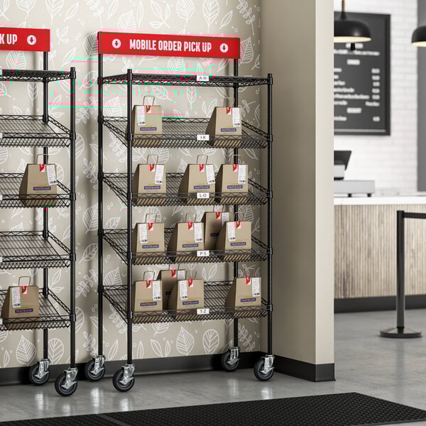 A Regency black epoxy shelving station with slanted drop in baskets on a shelf.