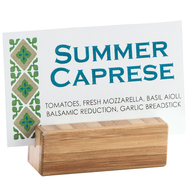 A business card on a bamboo Cal-Mil cardholder base.