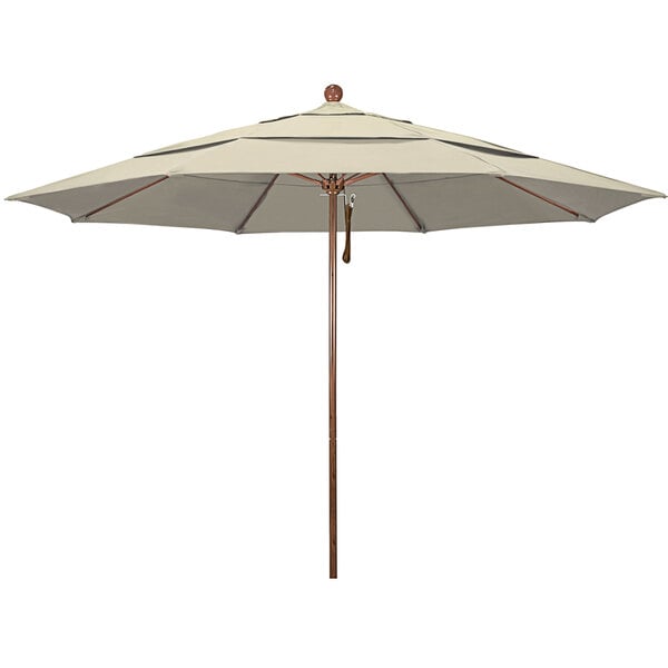 An antique beige California Umbrella with a wooden pole.
