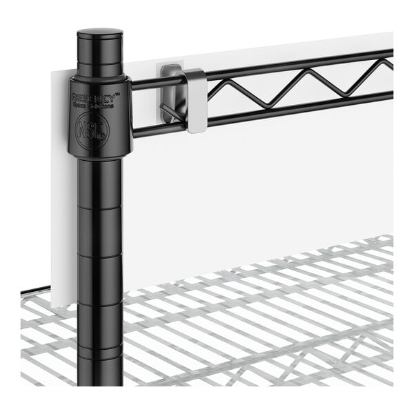 A metal shelving unit with a black vertical support post, a horizontal wire shelf, and a white panel attached to the back with a plastic clip.