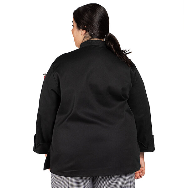 A woman wearing a black Uncommon Chef long sleeve chef coat.