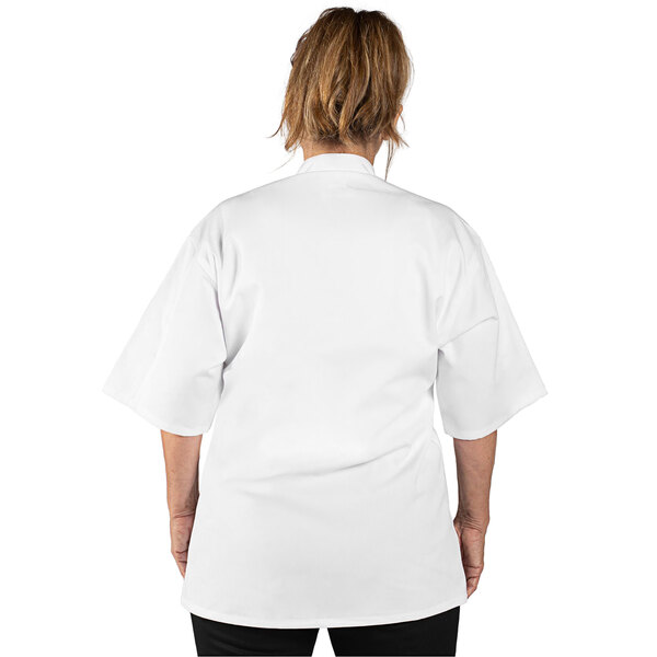A woman wearing a white Uncommon Chef short sleeve chef coat.